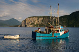 Fishermen leaving East Arm Bonne Bay at Norris Point at the end of the day with Shag Cliff