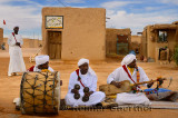 Gnawa music group in white turbans and jellabas sitting and playing music in Khemliya desert village Morocco