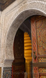 Open door of Mosque with intricate stone carving Zellige and paint in Fes Medina Morocco
