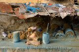 Fes leather tannery worker under decrepit roof painting raw hides with blue chromium by Wadi Fes Morocco