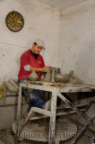 Worker throwing clay tagine pots on a turning wheel in a Fes el Bali Medina shop Morocco