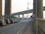 Ship passing through gap behind safety barriers.