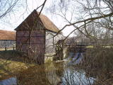Watermill behind trees