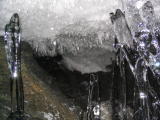 Clear-ice stalagmites, 3 tall, in front of long ceiling crystals.JPG