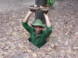 This guide, who was dressed up like a Vietcong soldier, was demonstrating an entrance to the tunnels.