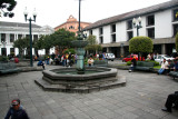 The fountain with pedestrians passing time in Plaza de la Independencia.