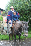 A cowboy with his son on horseback at the hacienda.