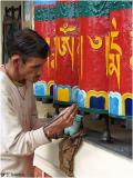 A man painting Tibetan prayer wheels, in the town which the Dalai Lama stays at; Mcleod-Ganj.