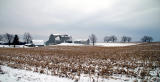 gray barn on river road in the winter. . .