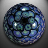 A fumed 'y' literally explodes from the depths of this galactic vortex, with a fancy pinwheel and scale pattern on the backside.