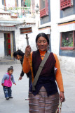 Tibetan woman spinning a large prayer wheel