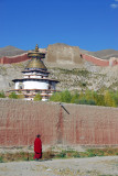 Monk walking along the walls of Pelkor Chöde Monastery