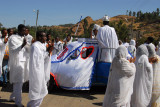 The wedding car is covered with a decorated white cloth