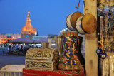 Touristy handicrafts shop, Souq Waqif, with the illuminated minaret of the Kassem Darwish Fakhroo Islamic Centre