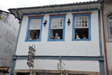 Shop on Rua Direita with figures posed to look out the window