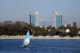 Twin towers of the Bank of Tanzania behind the seafront of Ocean Road, Dar es Salaam with an outrigger sailboat