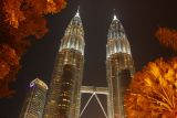 Petronas Towers, Kuala Lumpur, at night, with some trees