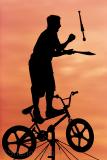 Busker on tightrope bicycle