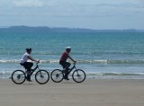Biking along Manly Beach Whangaparaoa.