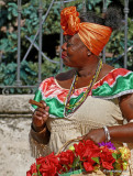 Lady in traditional garb smoking a Cuba cigar,  Havana, Cuba