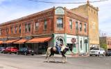 A resident on horseback rides down the street in Jerome Arizona