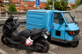 Parking lot at the Dragon Bridge in old town of Ljubljana Slovenia with motorcycle and tiny blue three wheeled truck