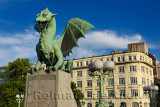 Green copper Dragon statue on concrete pedestal of Dragon Bridge over the Ljubljanica river symbol of Ljubljana Slovenia with la