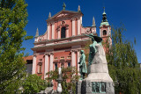 National poet France Preseren statue Monument with muse in front of pink Franciscan Church of the Annunciation in Ljubljana Slov