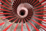 View down the steel double helix spiral staircase at the Ljubljana Castle tower with red bar posts and ornate steps Ljubljana Sl