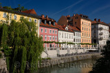 Bright pastel colors of renovated historic buildings Hribar Quay embankment of the Ljubljanica river canal waterway of Ljubjlana