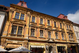 Gold colored historic building built 1898 on Old Square Stari trg with street shops Ljubljana Slovenia with blue sky
