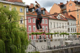 Young man balancing on a slack line high over the Ljubljanica river canal in the old section of Ljubljana Slovenia Europe