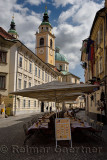 Empty restaurant tables for tourists on the street at Cyril Methodius Square with St. Nicholas church Ljubljana Cathedral in Lju