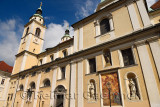 Southern facade of St. Nicholas church Ljubljana Cathedral Slovenia with belfry, frescoe, and statues of saints Joseph, Hermagor