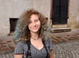 Gray brown picture of teenager tourist with curly blue denim tinted hair with blue eyes in street of Ljubljana Slovenia
