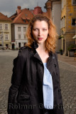 Young attractive woman standing in the cobblestone Upper Square with the Hercules fountain of Old Square in the old town of Ljub
