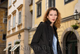 Young attractive female tourist with trench coat in Upper Square of the old town of Ljubljana Slovenia