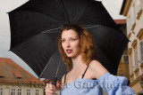 Attractive female tourist under an umbrella in drizzle at Old Square of the old town section of Ljubljana Slovenia