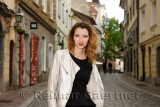 Grinning attractive woman standing on cobblestone street of Upper Square or Gornji trg in old town of Ljubljana capital city of 