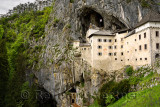 Cliff cave forest and entrances at Predjama Castle 1570 Renaissance fortress built into the mouth of a cliffside cave in Sloveni