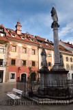 Pink frescoes on Old Town Hall building in the Town Square of Skofja Loka Slovenia with Mark of Mary ionic column monument