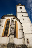 White exterior chancel sanctuary and belfry clock tower of Saint Jacob Parish Church in Skofja Loka Slovenia against a blue sky