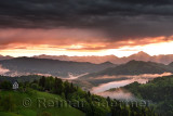 Sunrise in the mountains of Kamnik Savinja Alps with Storzic peak on right in pink fog over Skofjelosko Hills near Ljubljana Slo