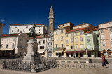 Tartini Statue in Tartini Square Piran Slovenia with St. George's Parish Roman Catholic Church and clock and bell tower