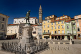 Tartini Statue monument in Tartini Square Piran Slovenia with St. George's Parish Roman Catholic Church and clock bell tower wit