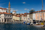 Piran Slovenia with inner harbor lined with boats and Tartini Square with St George's Cathedral with St Marks Venice belfry repl