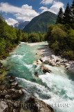 Cold clean emerald green water of the Upper Soca River Valley near Bovec Slovenia with Veliko Spicje mountain Julian Alps