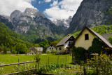 Garden and houses in Trenta Slovenia with Pihavec and Triglav mountain peaks in Triglav National Park Julian Alps in Spring