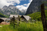 Tourist information center and firewood and fence in alpine village of Trenta with Pihavec peak Triglav National Park Slovenia