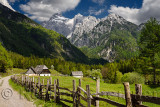 Local Bovec Trenta farmhouse architecture in high alpine valley of Zadnja Trenta with snow capped Razor Peak in Triglav National